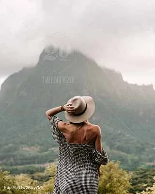 Mujer de pie de espaldas, tomando con su mano un sombrero en su cabeza, al fondo unas montañas conviértete en voluntario internacional