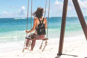 Mujer en columpio frente al mar antes de cruzar de Colombia a panamá
