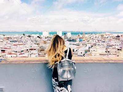 Mujer en un balcón haciendo su voluntariado tomando fotografías