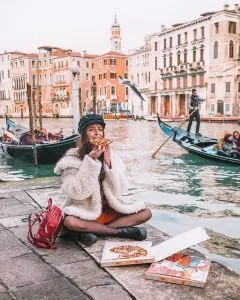 Mujer comiendo en Venecia sin miedo a viajar
