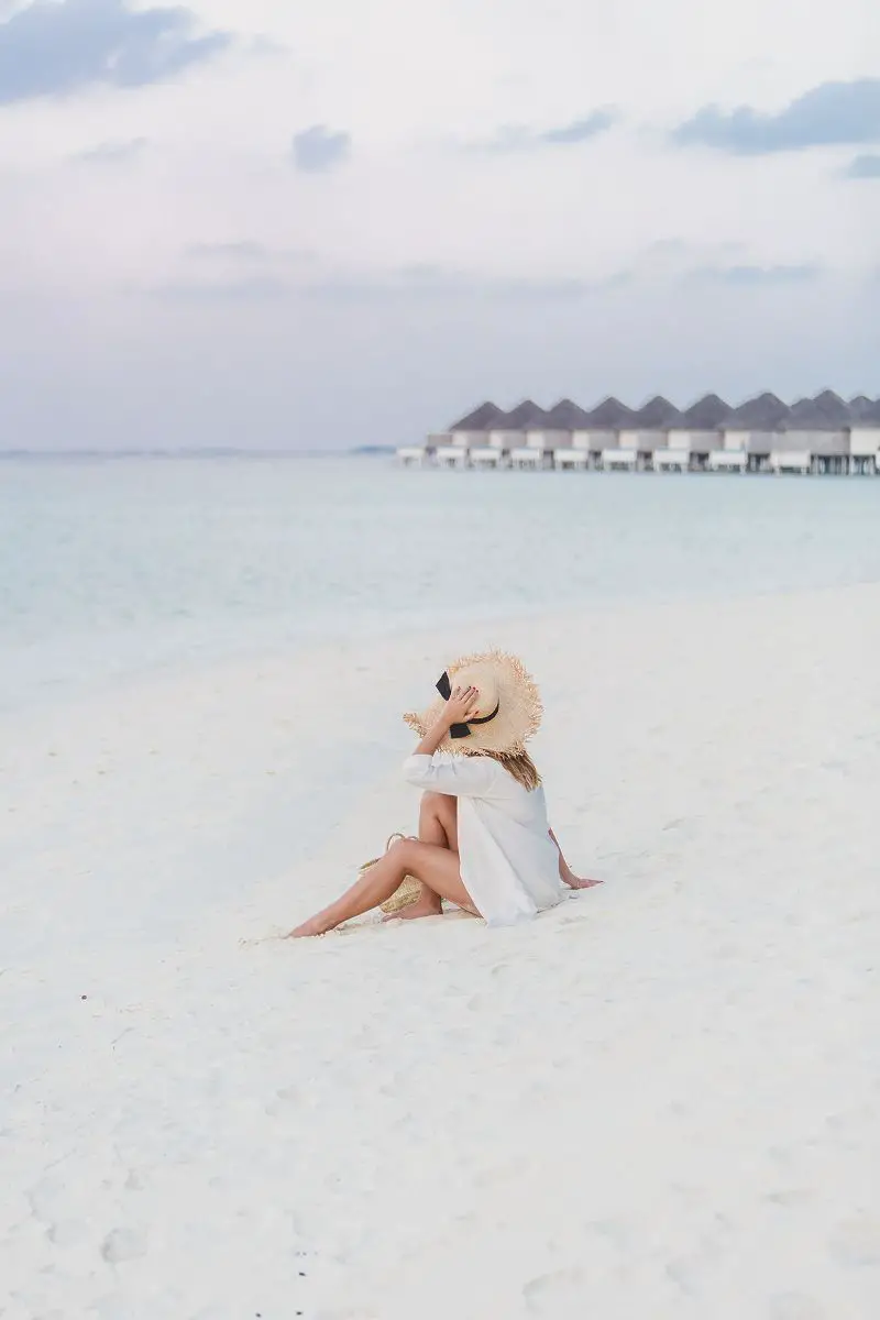 Mujer en la playa mientras viaja por el mundo cuidando mascotas