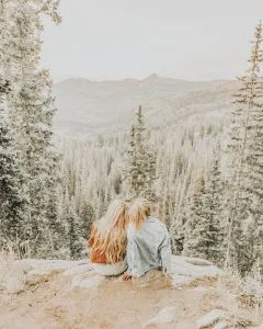 Dos mujeres mirando un bosque mientras son voluntarias
