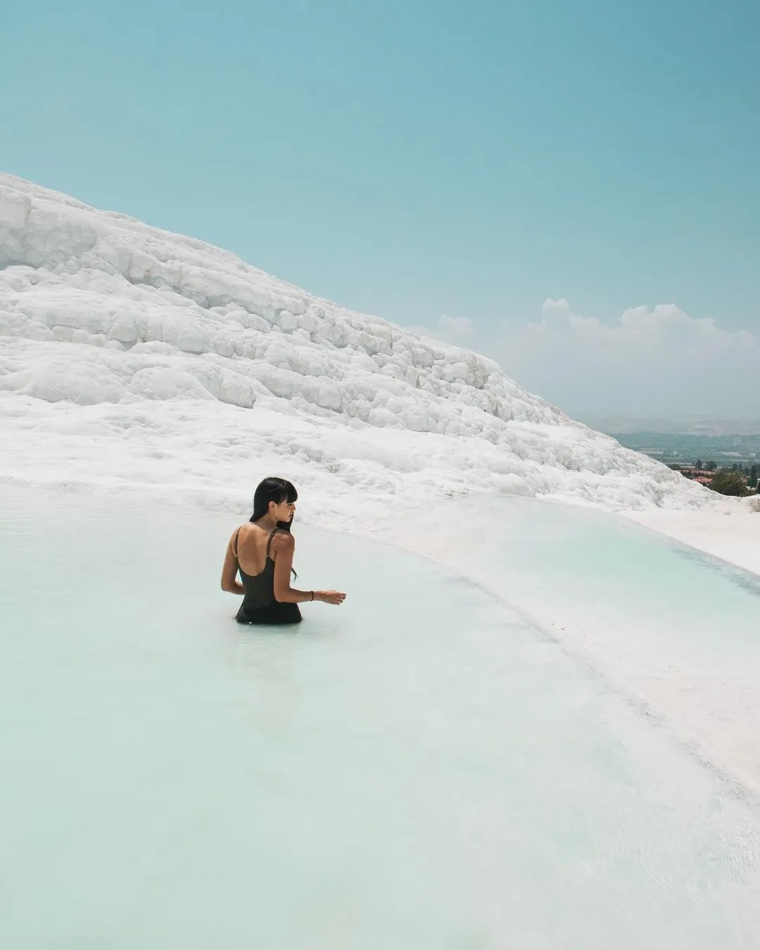 Mujer en una piscina climatizado de espaldas, texto superpuesto con uno de los requisitos para ser voluntario: tener una cuenta verificada en Worldpackers